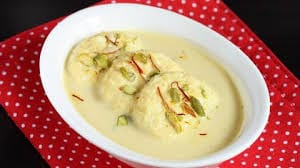Photograph of 3 rasmalai pieces served on a plate.